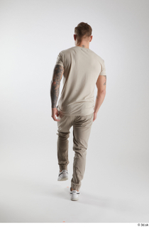 Gilbert 1 back view dressed grey t-shirt grey trousers walking…